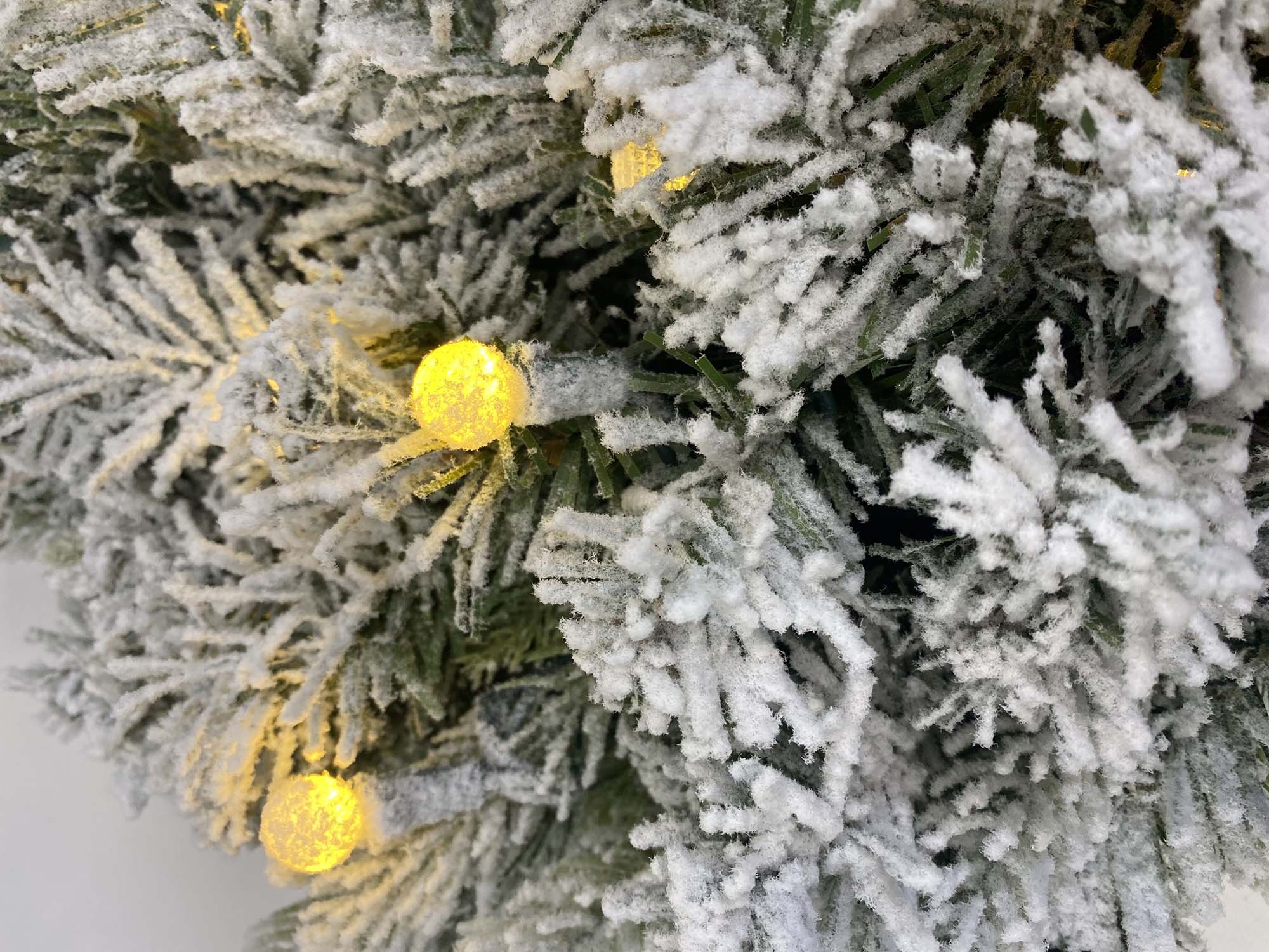 Pre lit flocked Christmas wreath with warm white LED lights and snow covered pine needles. This artificial winter wreath adds cozy festive charm to front doors, mantels, and indoor holiday decorations