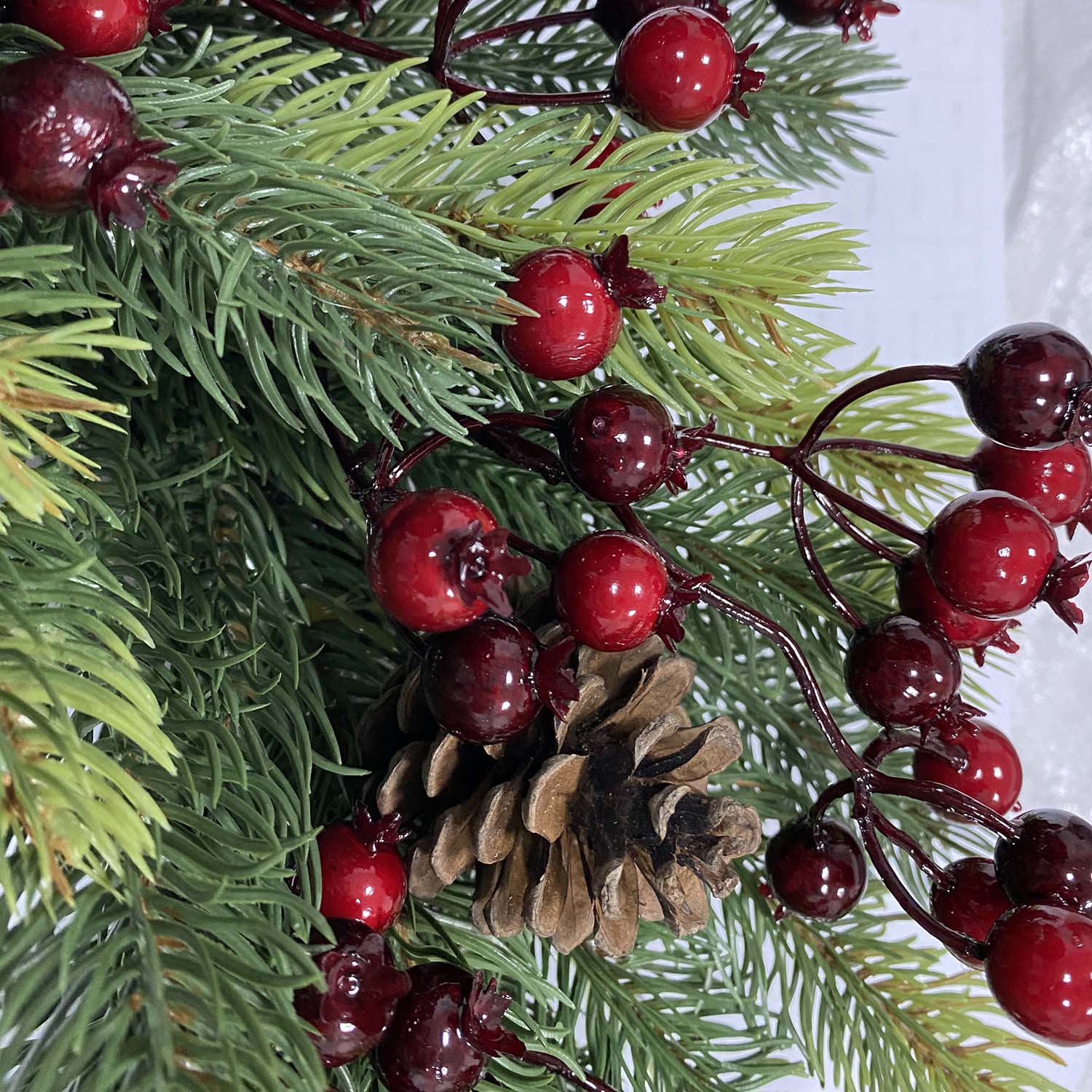 Kaufen Sie hochwertige künstliche Weihnachtskränze mit Beeren und Tannenzapfen. Perfekt für professionelle festliche Tür- und Wanddekoration.