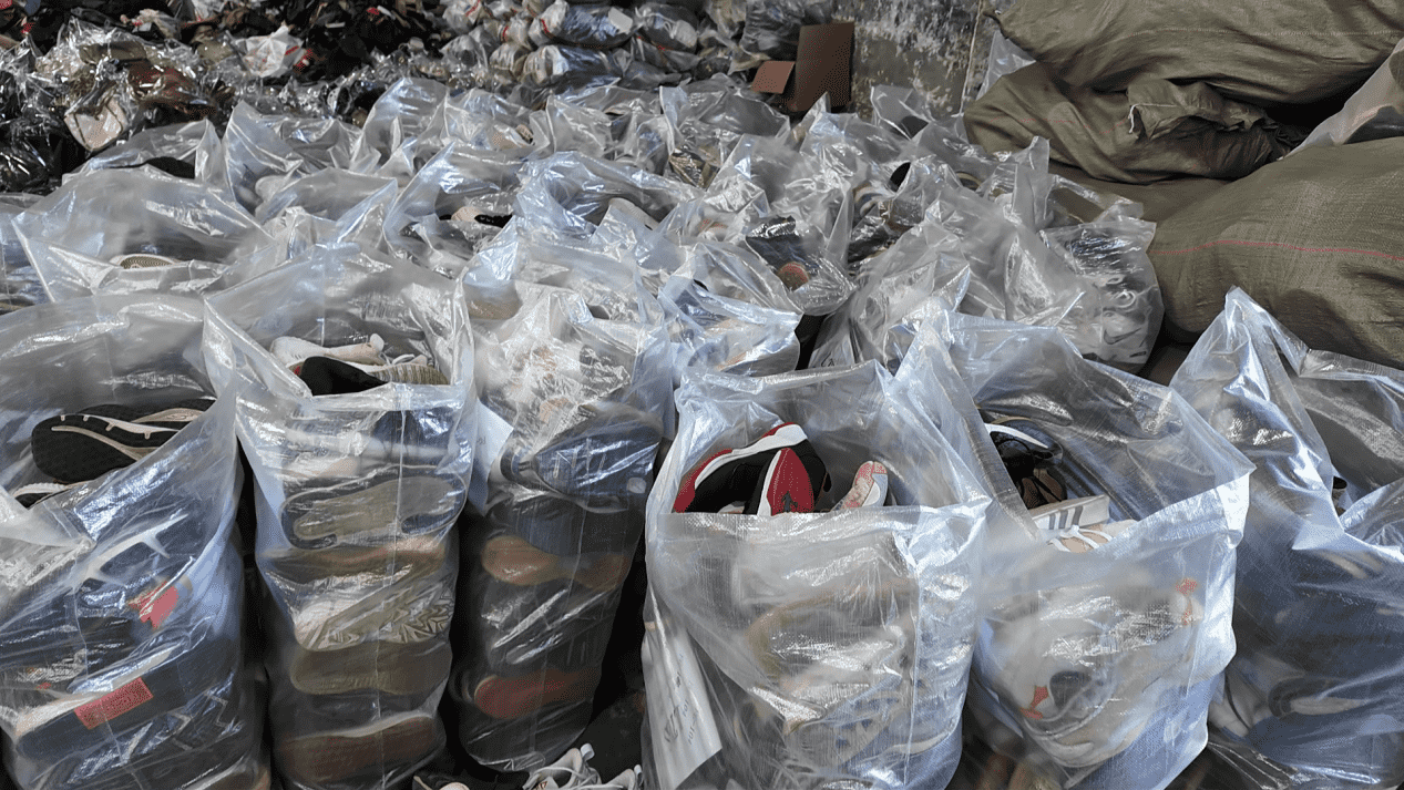 25kg transparent sacks of wholesale used men shoes for export.