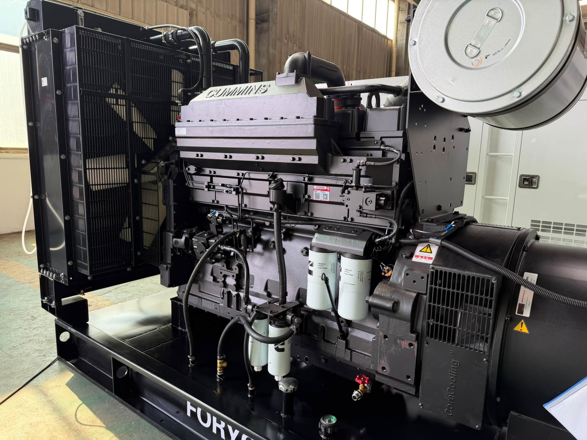 Close-up of Cummins branded diesel engine and radiator in an open type generator set
