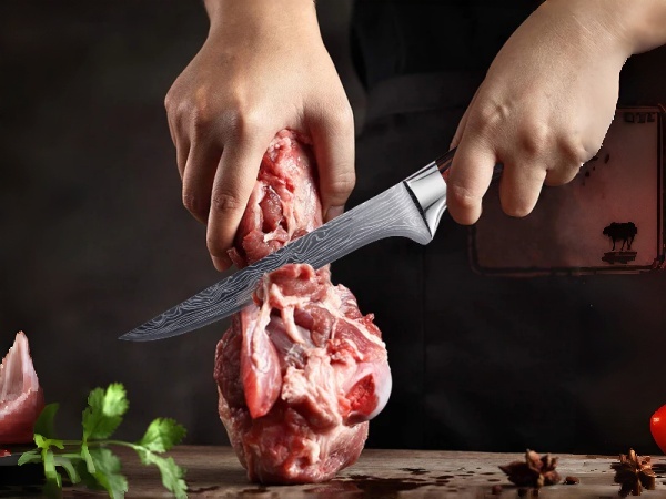 Chef trimming beef with boning knife