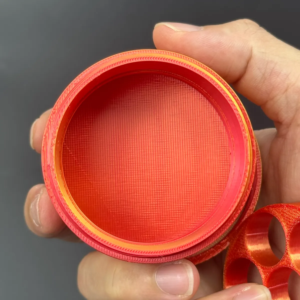 the red-orange gradient cylindrical vial case with its tray lifted out