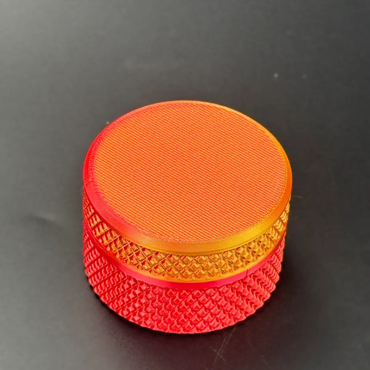 the red-orange PLA gradient cylindrical vial case on its own