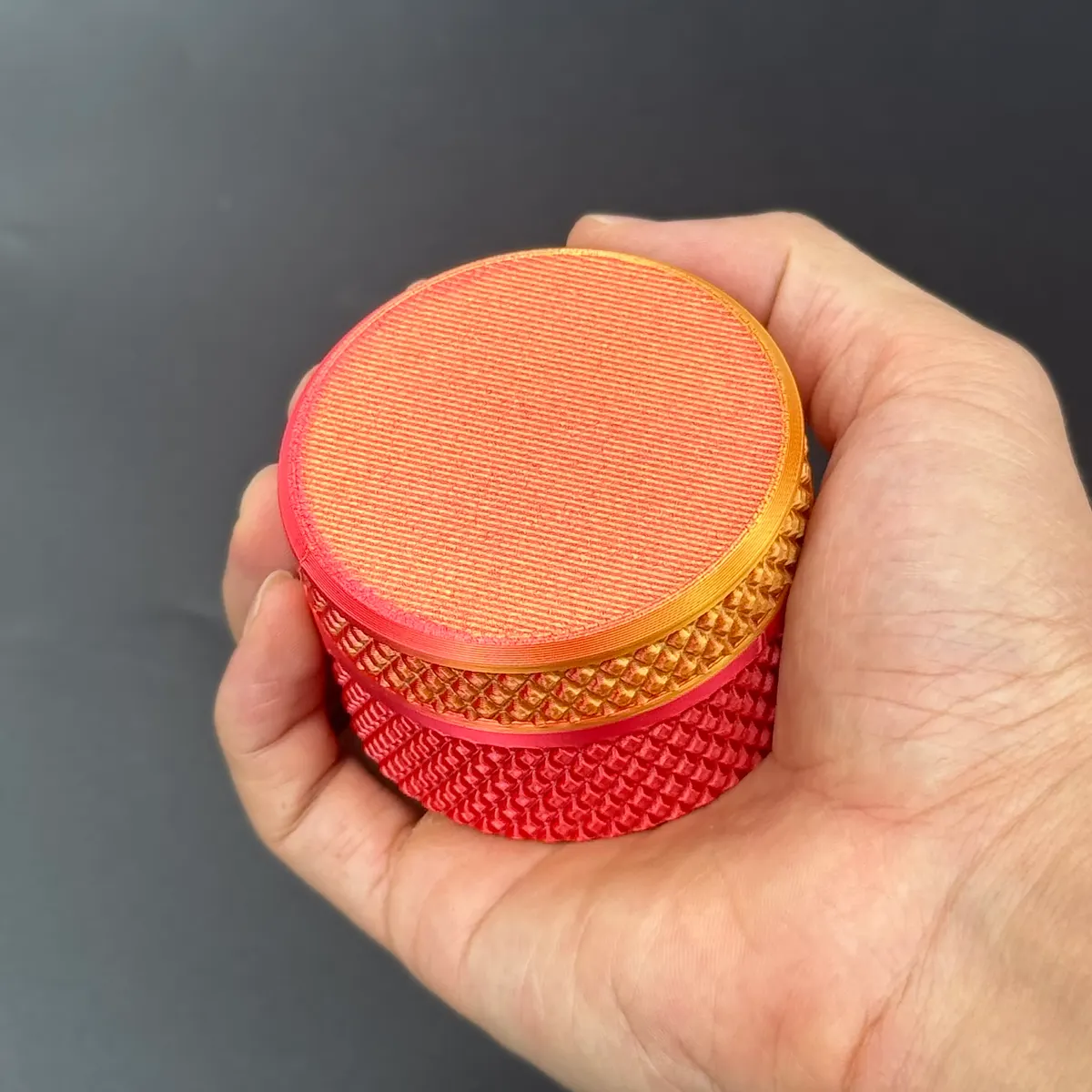 the red-orange gradient vial case held in a hand