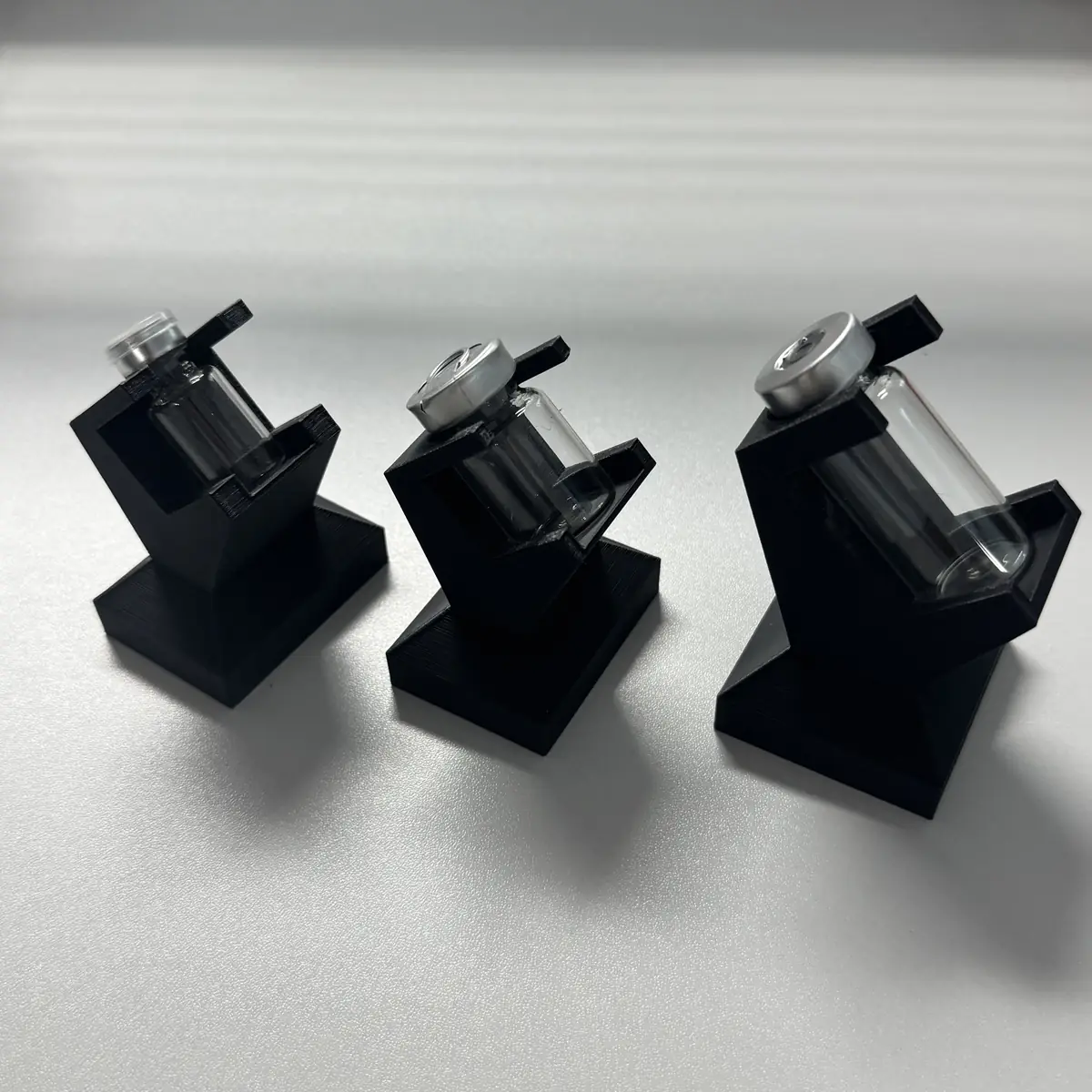 side view of three vial display stands showing the 45 degree presentation angle