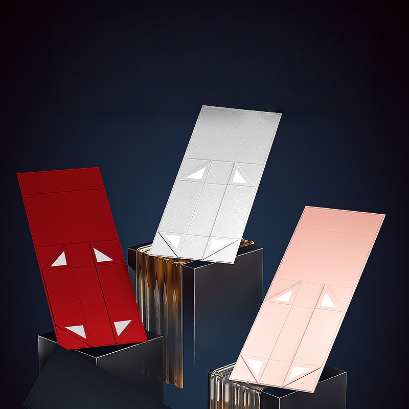 HC.PRINTERS luxury gift boxes in red, white, and pink — open to reveal internal compartments, displayed on black pedestals against a dark background, ideal for premium gifting and custom packaging