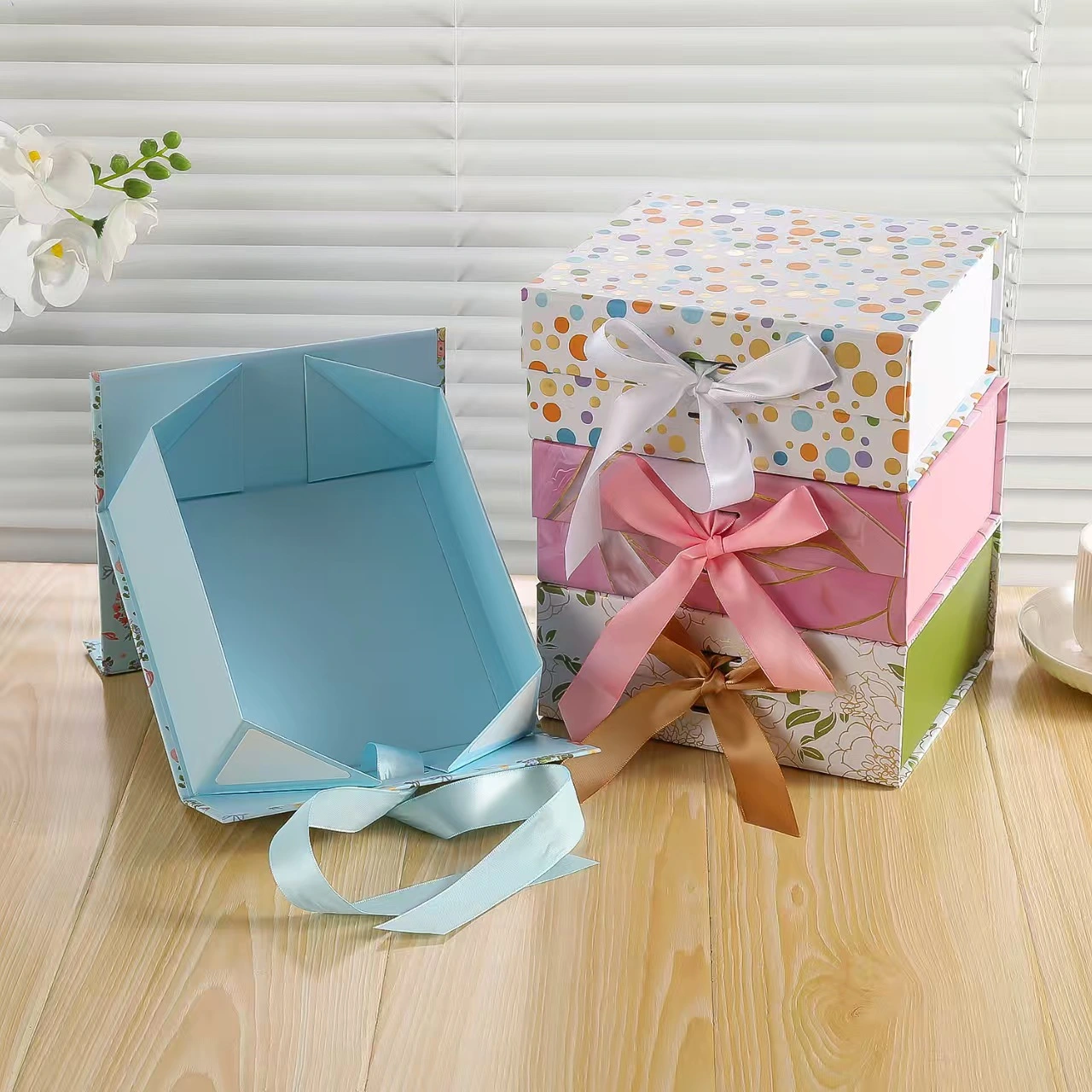 Assorted colorful polka dot and solid gift boxes with ribbon bows, square folding paper boxes
