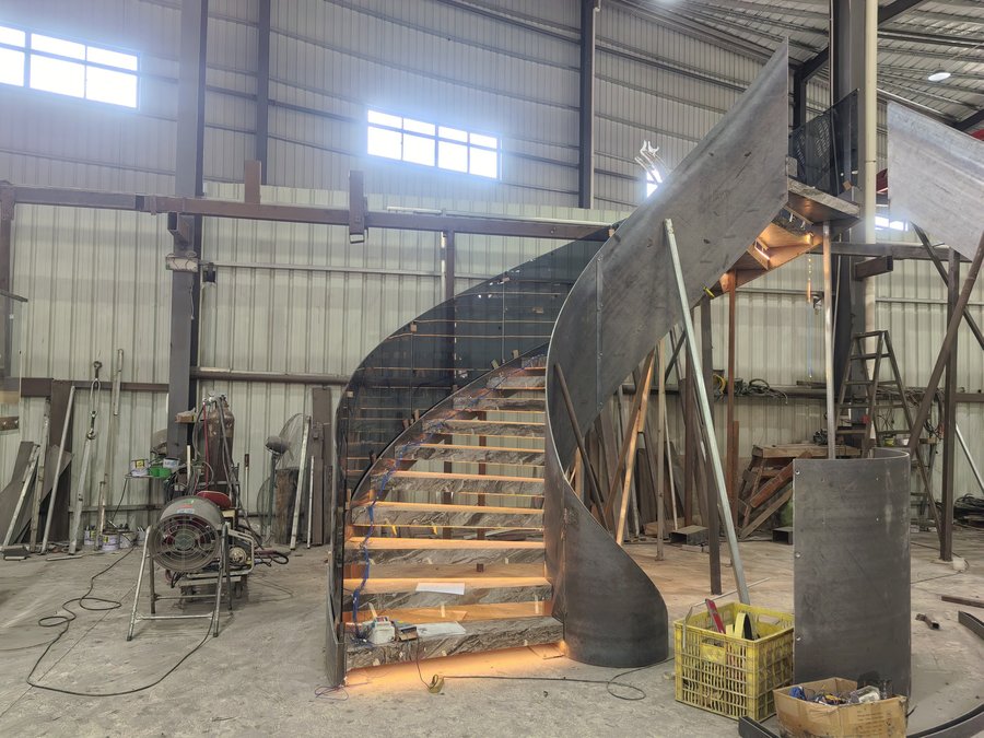 Curved stone staircase with under-tread lighting during factory trial assembly in the workshop