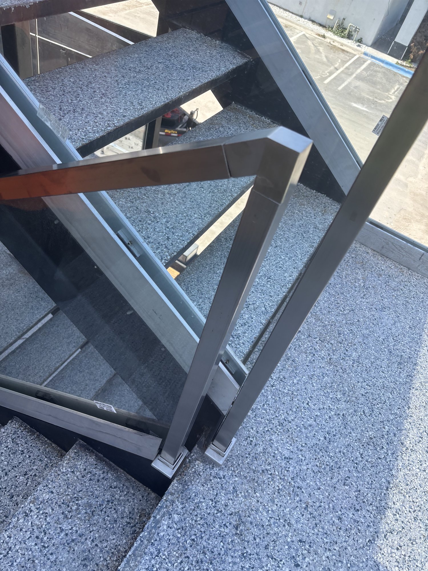 Brushed-metal posts and glass railing on outdoor stone steps