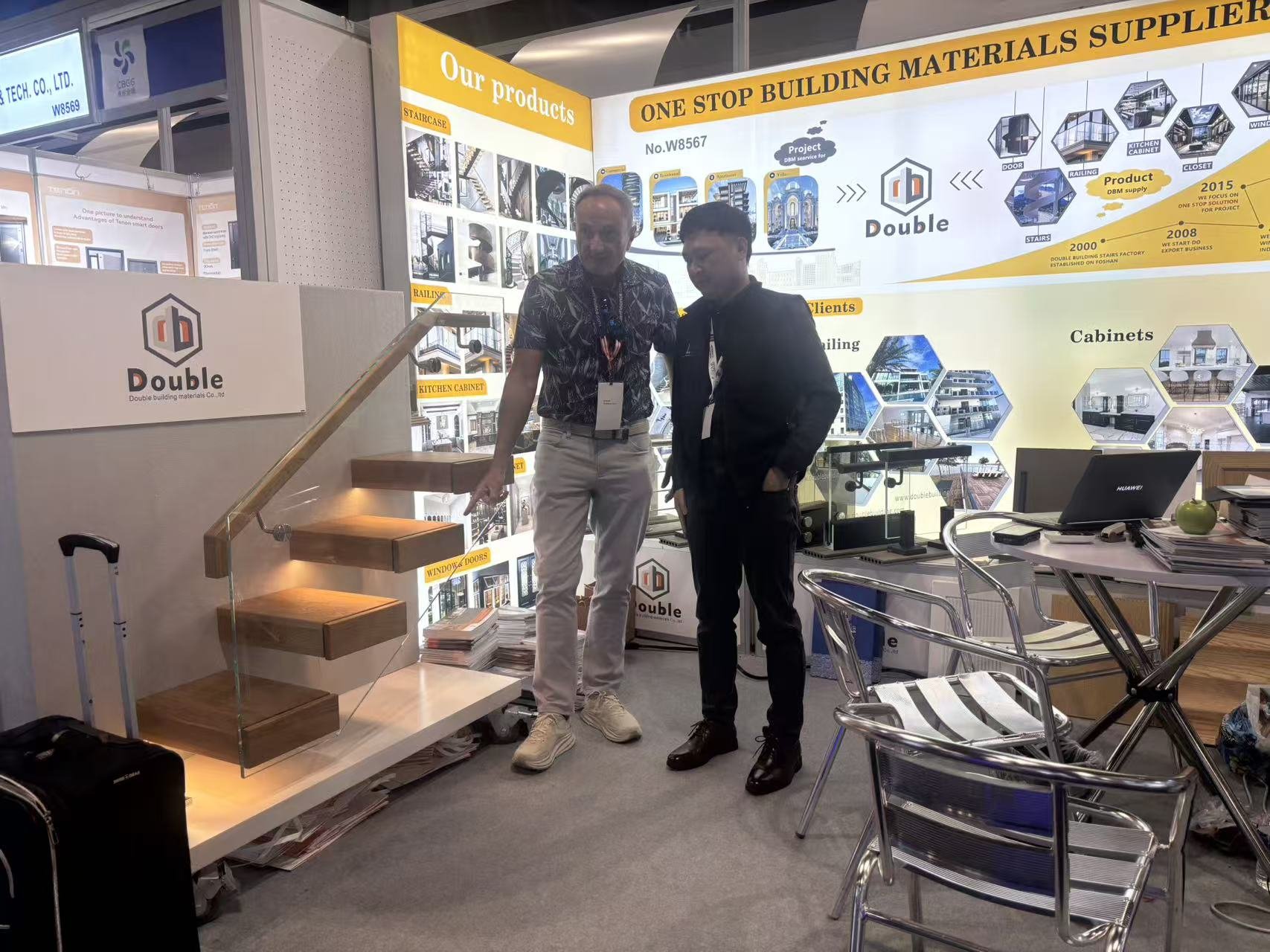 Visitor pointing under a tread of the floating staircase sample at the IBS 2026 booth