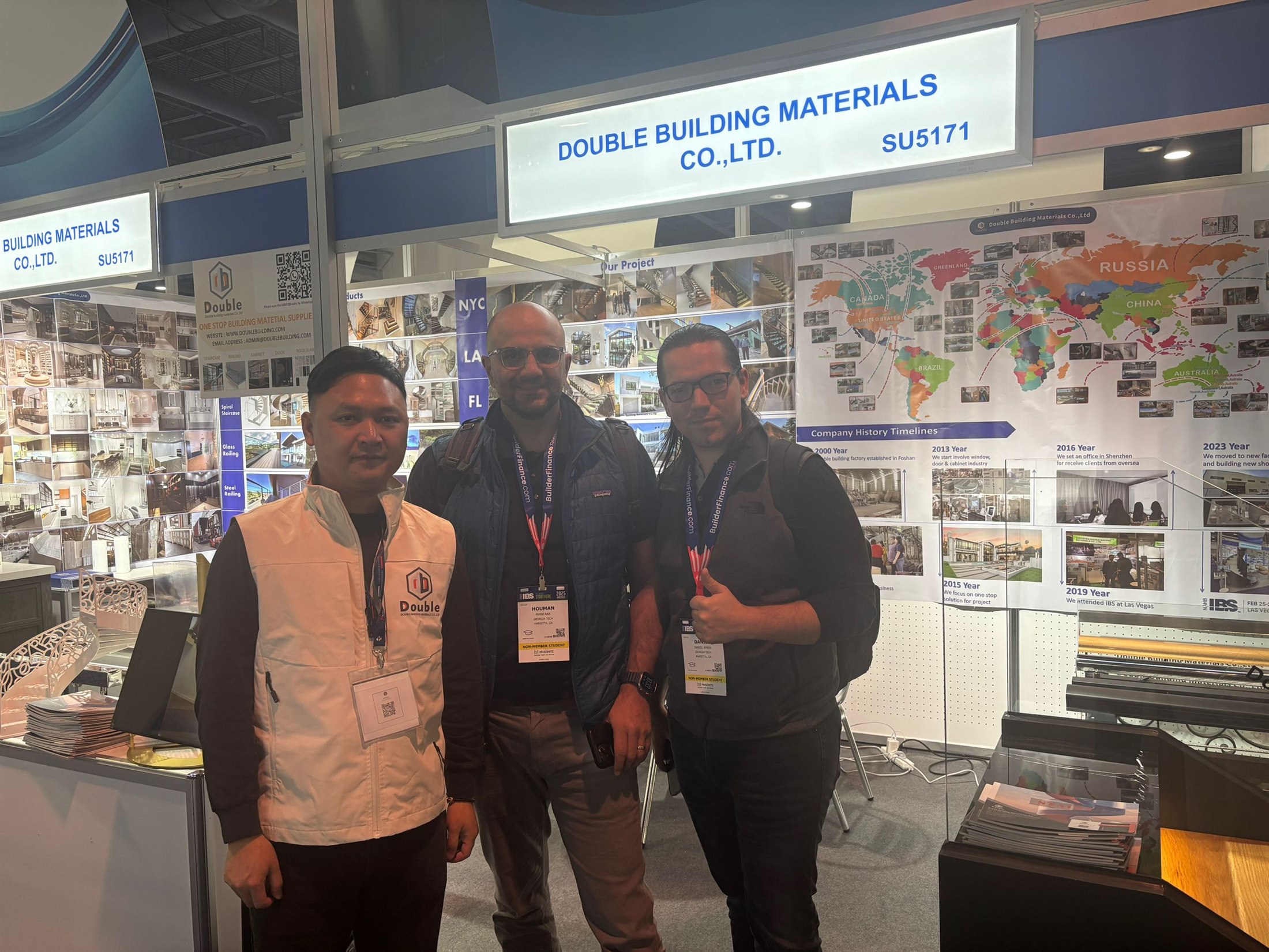 Staff and visitors standing together in front of the world-map wall at booth SU5171