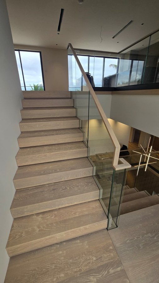 White oak treads with frameless glass balustrade and matching wood handrail detail