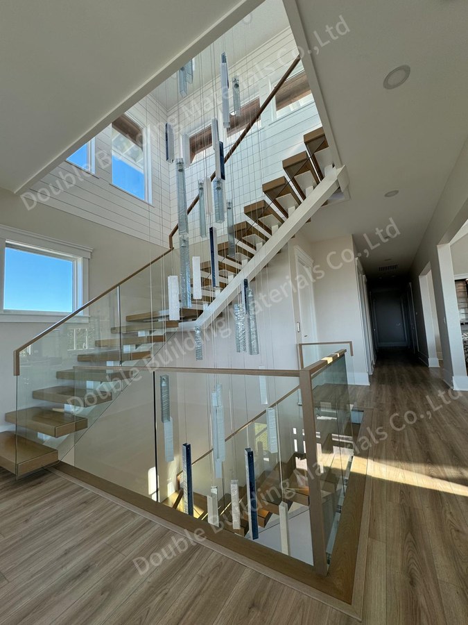Low angle of white square tube staircase with frameless glass and wood handrail