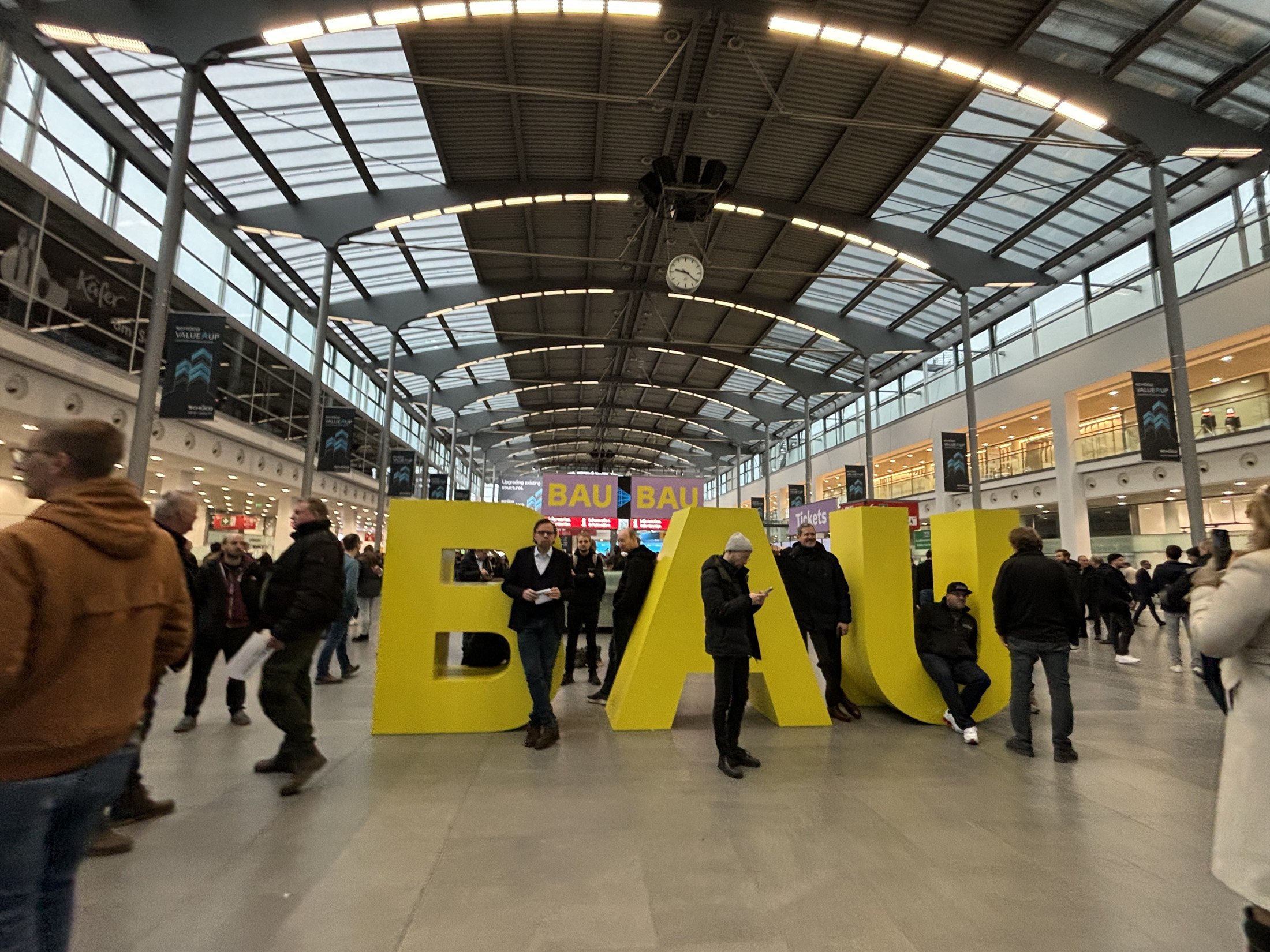 Yellow three-dimensional BAU letters under the glass roof at Messe München