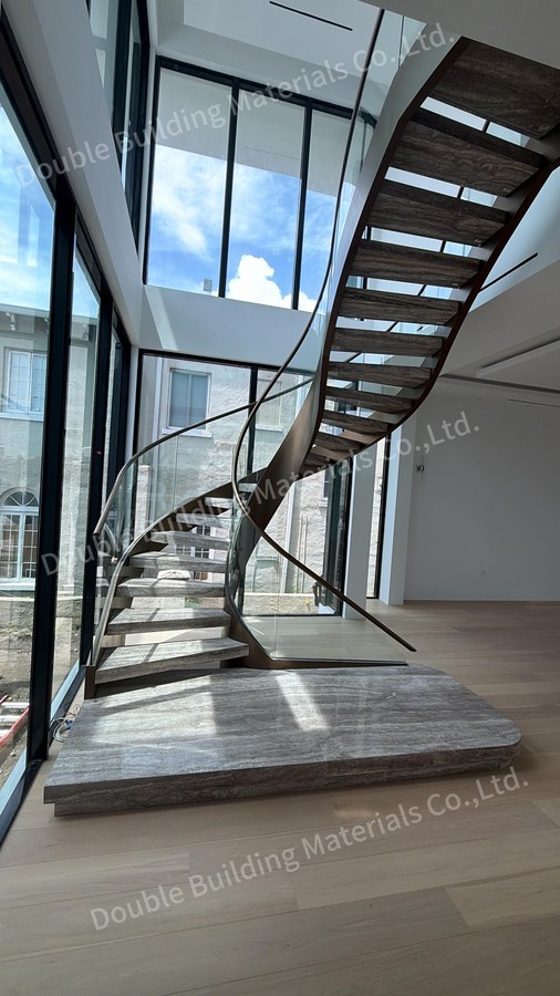 Close view of curved travertine treads against a bronze dual tone stringer with open risers
