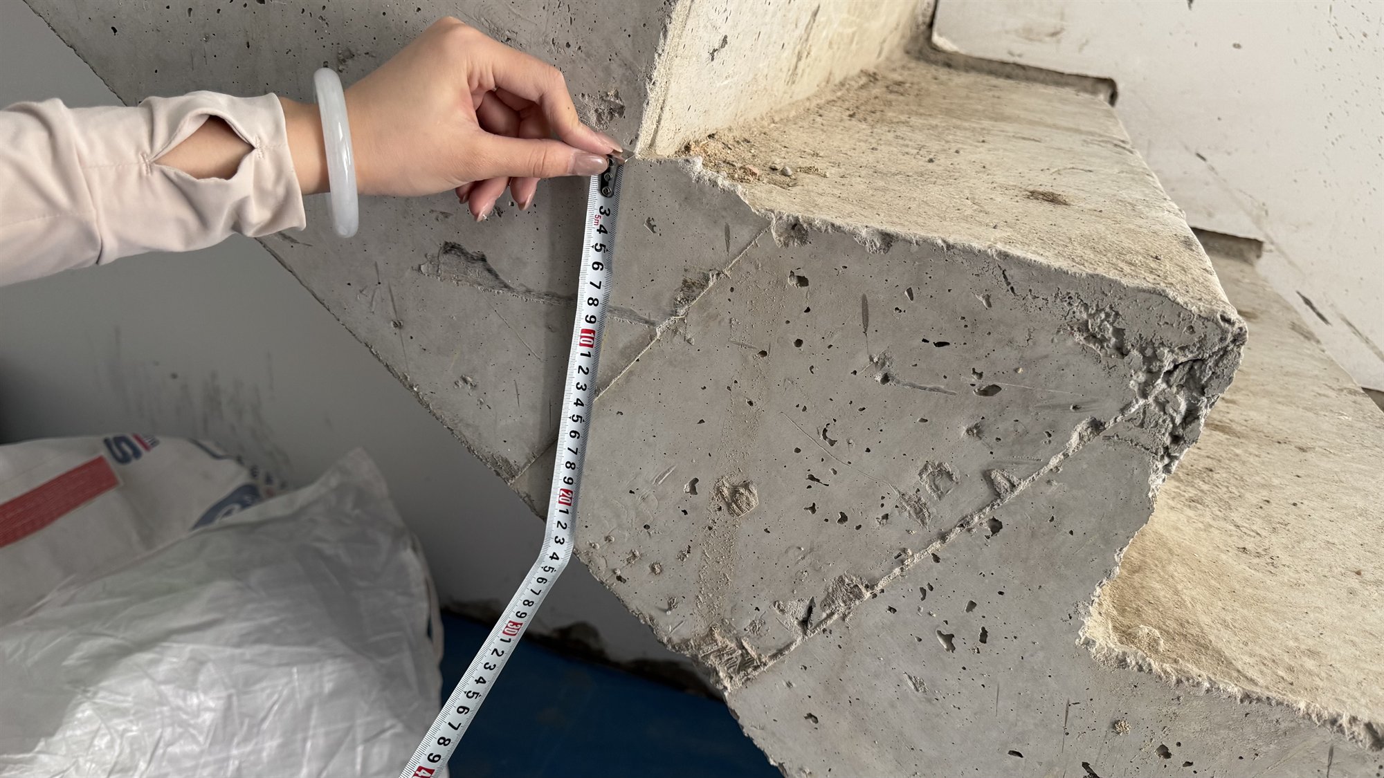 Tape measure held against an unfinished concrete stair at a Sydney home under construction
