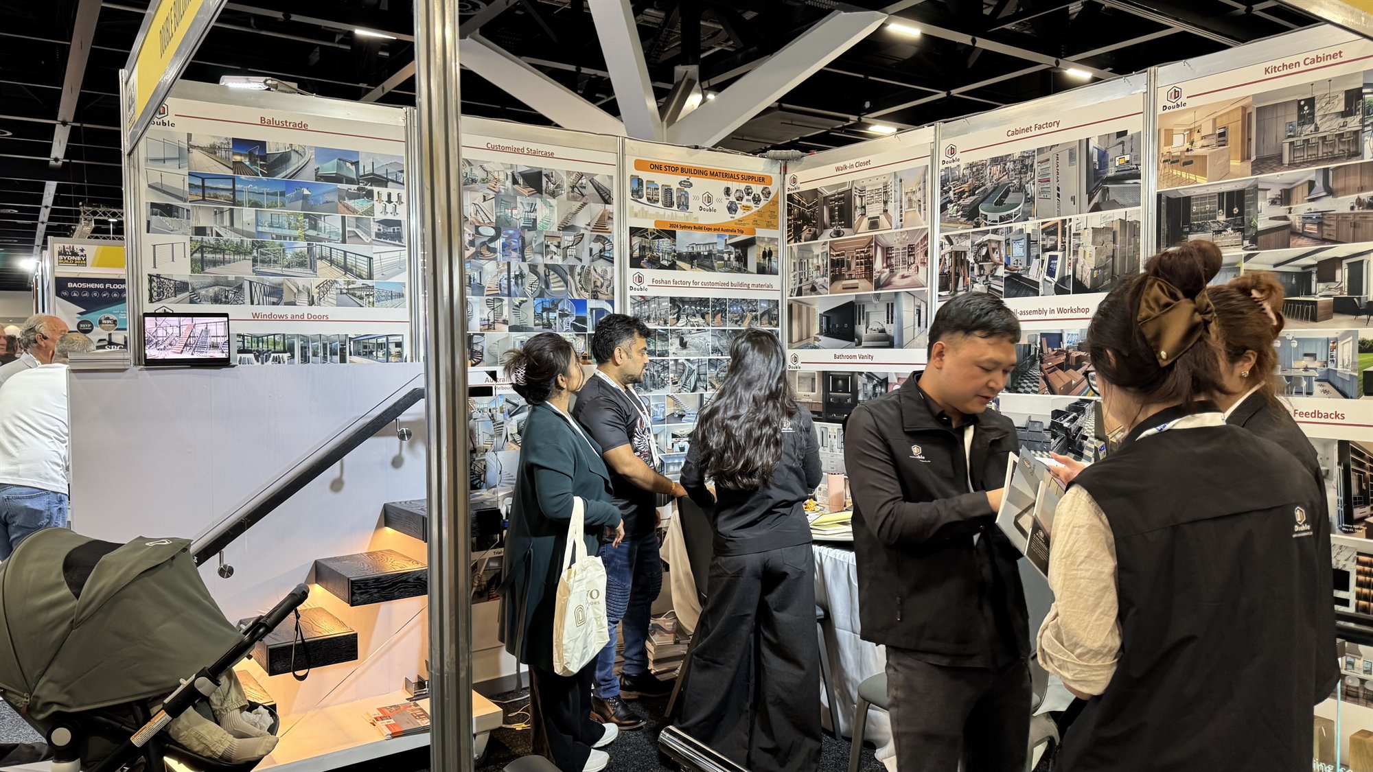 Staff showing a catalogue to a visitor at booth U25