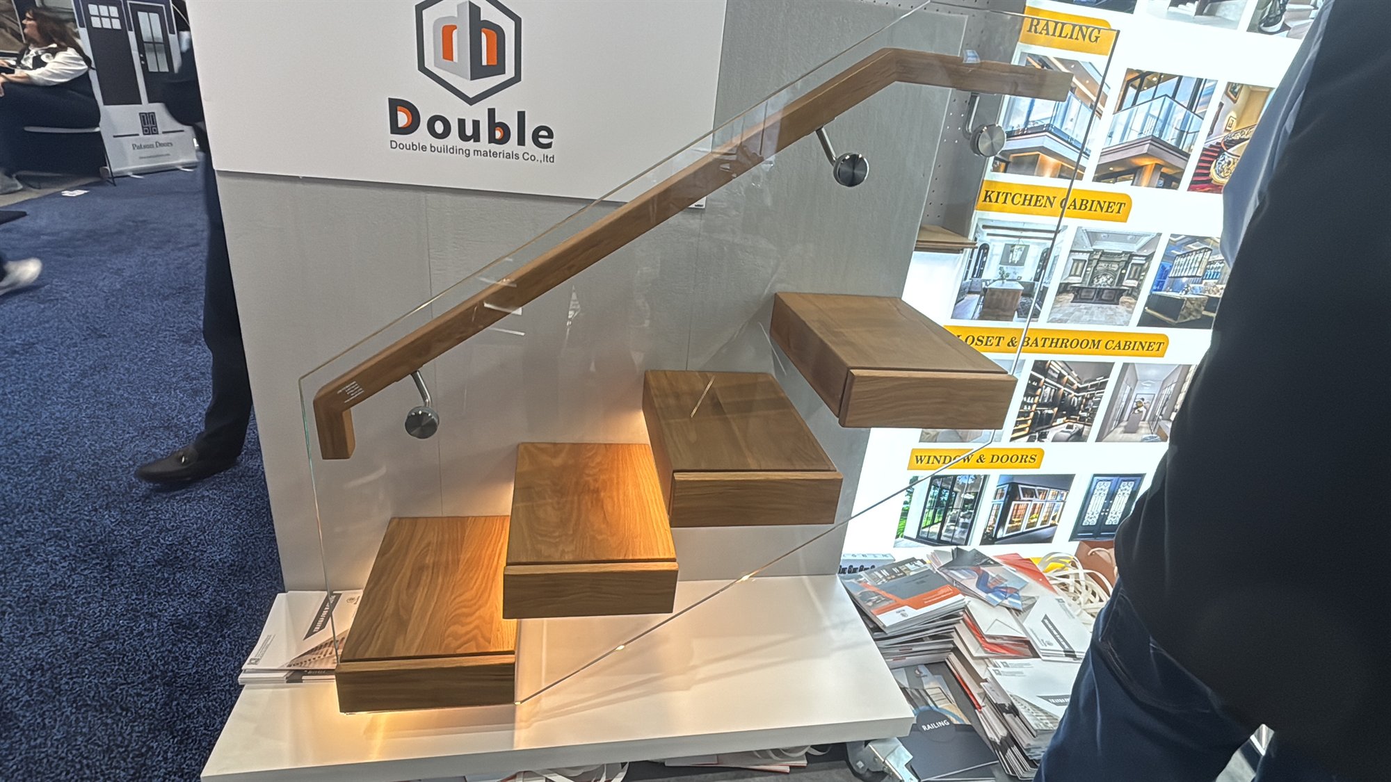 Floating staircase sample with wood treads, glass railing and under-tread light at the IBS 2026 booth