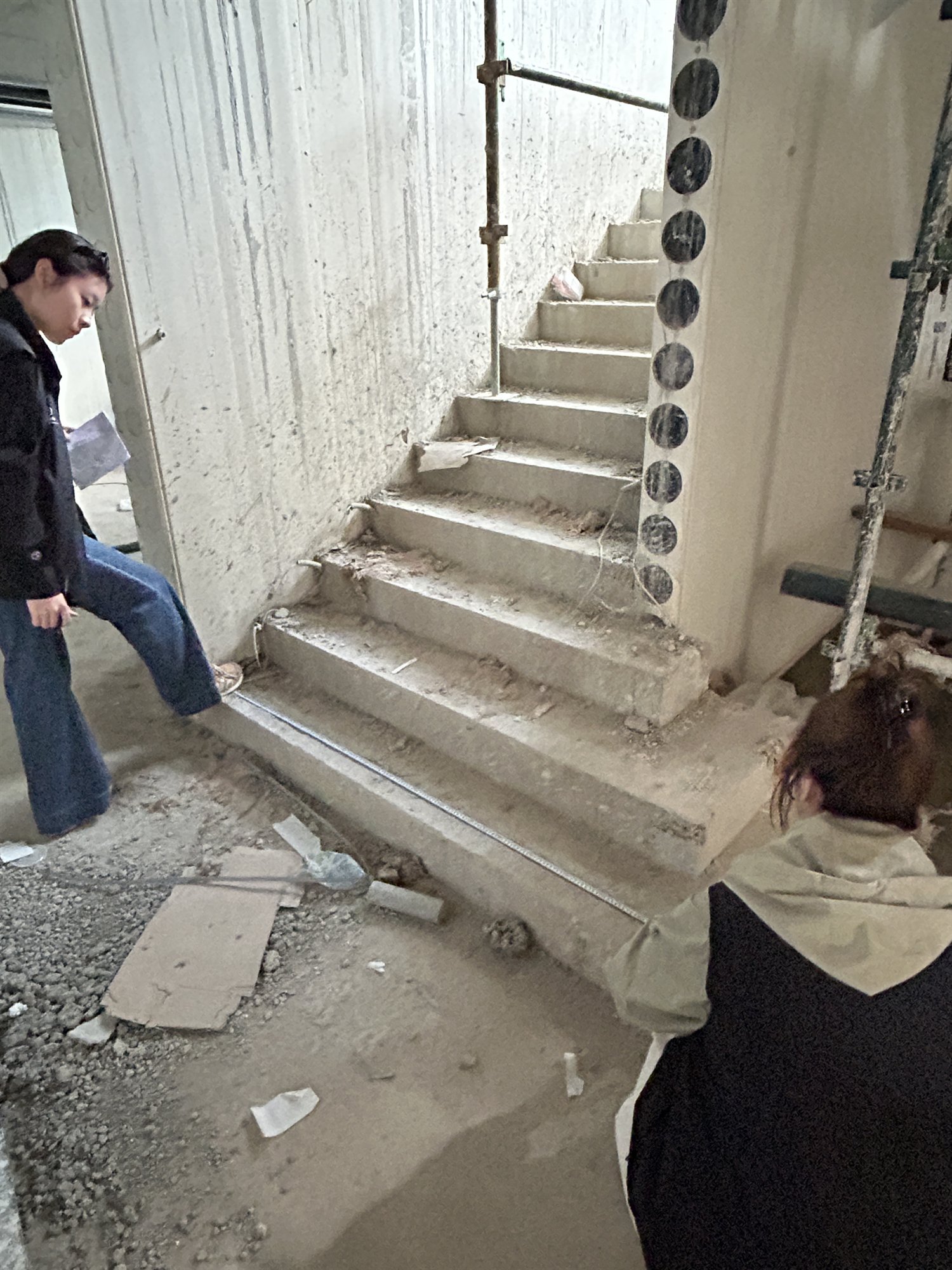 Staff measuring an unfinished concrete winder stair in a Sydney home under construction
