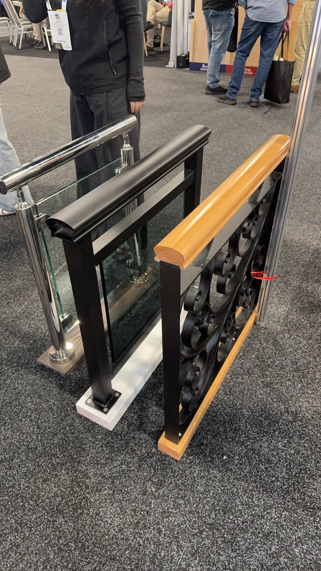 Three railing samples at Sydney Build 2026: glass with a metal top rail, dark glass in a black frame, and ornate iron with a wood handrail