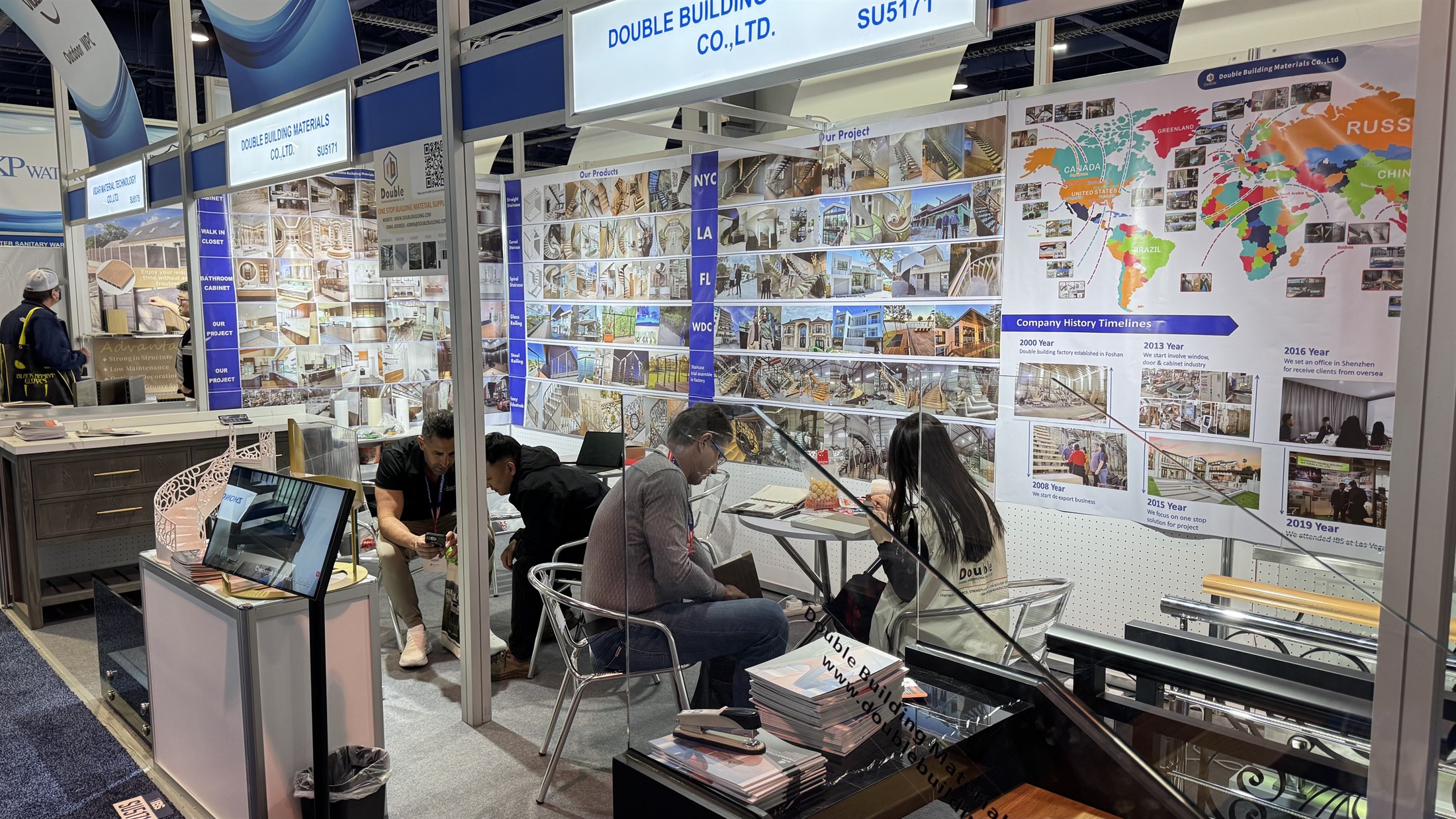 Visitors and staff seated at the consultation table with catalogues at booth SU5171