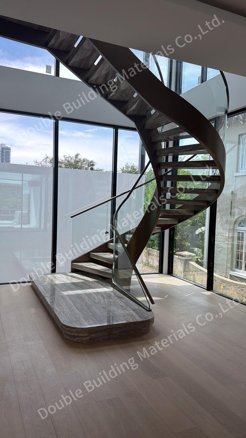 Curved travertine staircase with dual tone stringers and curved glass balustrade in a Miami atrium