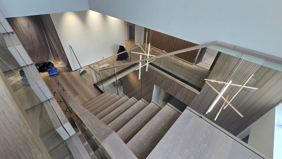 Florida stairwell overview of stacked white oak staircase with glass and wood handrail