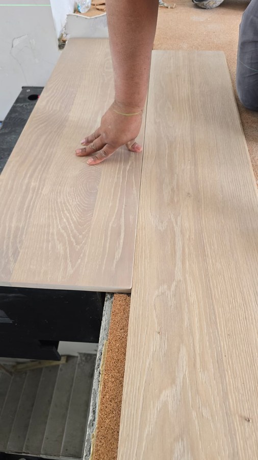 On-site white oak finish sample boards at a stair landing edge