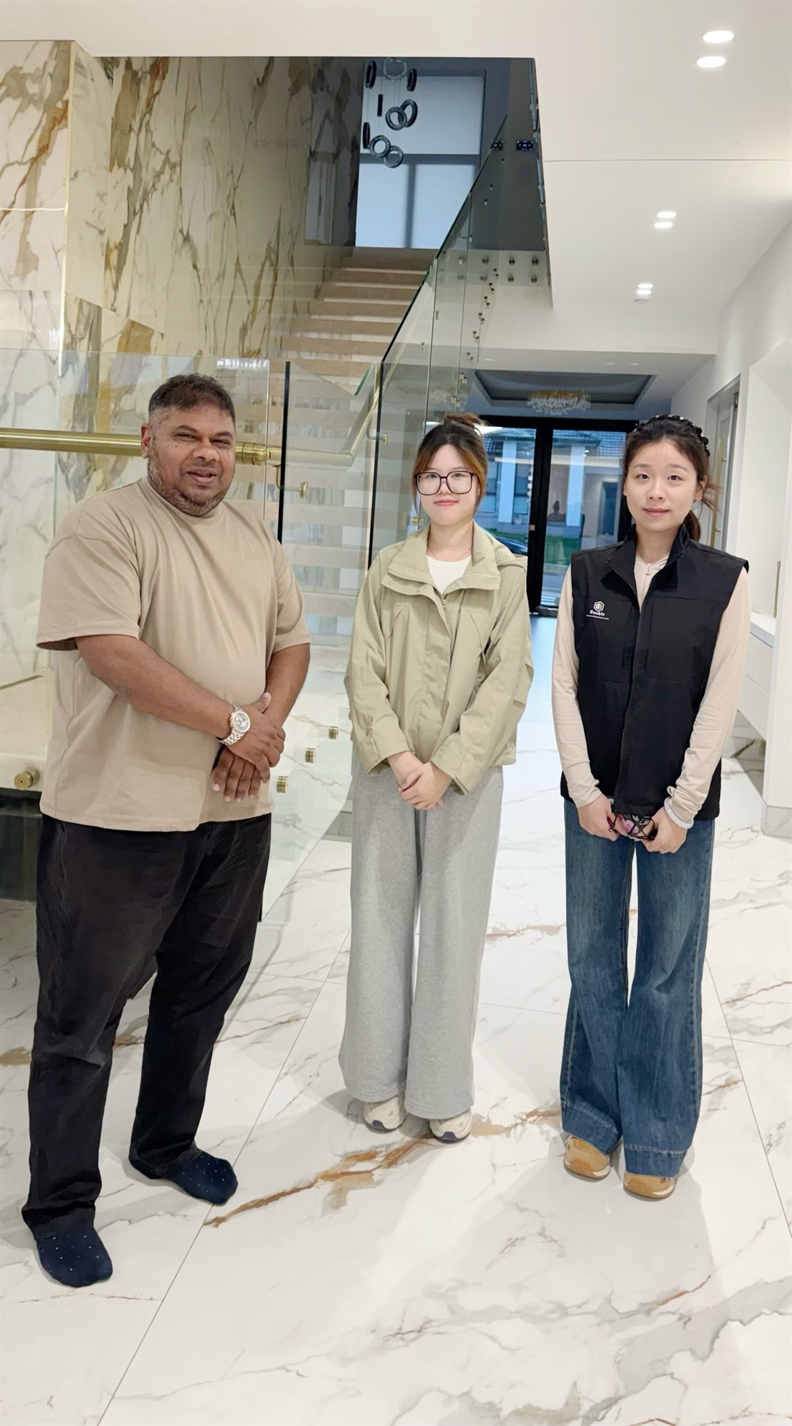 Staff standing with a contact beside a glass-railed staircase in a finished Sydney foyer