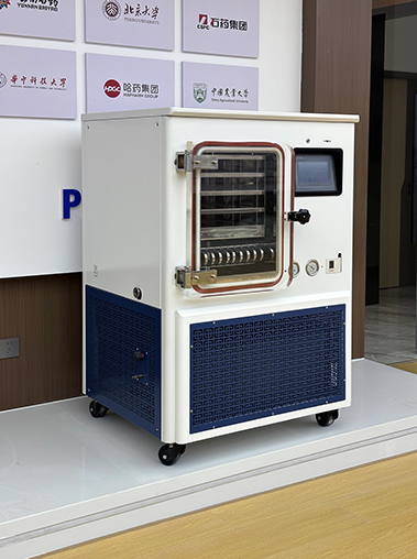 Left perspective view of a commercial laboratory freeze dryer on display in a showroom with university partner logos.