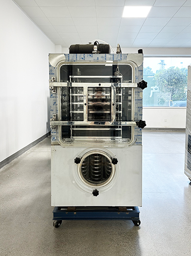 Perspective real shot of a vacuum freeze dryer machine with an open steel frame and blue protective film in a bright factory room.