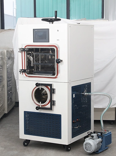 Three-quarter right view real shot of a laboratory freeze dryer showing its white casing, side cooling vents, and vacuum hose connection to an external pump.