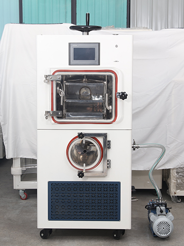 Front view real shot of a dual-chamber cabinet vacuum freeze dryer lyophilizer machine connected to an external blue vacuum pump on a concrete studio floor.