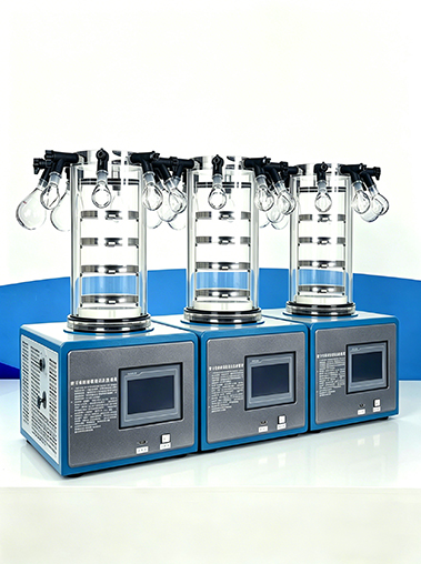 A row of three Geliss laboratory manifold freeze dryers lined up on a white table, showcasing the uniform quality and multi-unit setup.