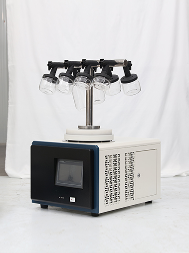 Side view of Geliss compact lyophilizer equipment showcasing the side mesh cooling vents, black front panel with touch screen, and top T-shaped manifold.