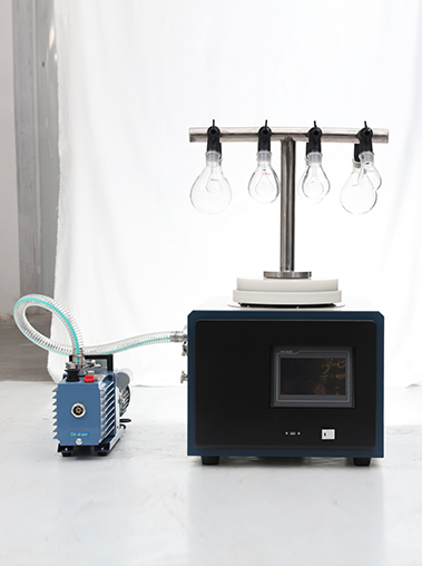 Front view of Geliss laboratory freeze dryer with T-shaped manifold and eggplant flasks, connected by a transparent vacuum hose to a blue rotary vane vacuum pump.