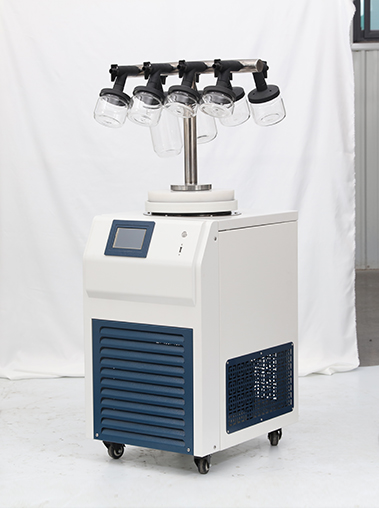 Left side angled setup of a Geliss lyophilizer machine with a T-frame manifold, showing the vacuum hose connection to an external pump.