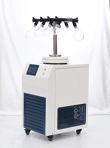 Right angled view of a laboratory freeze dryer showing a T-frame manifold with clear glass flasks and blue ventilation grilles on the cabinet side.