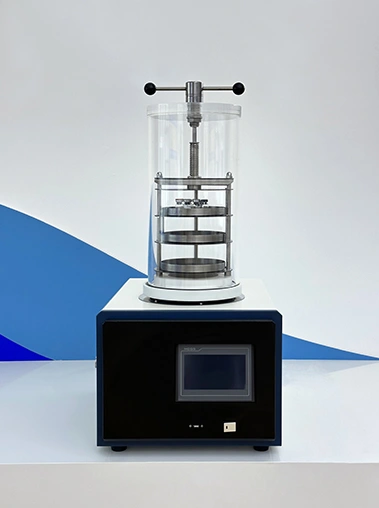 Front view of a stoppering type laboratory freeze dryer with an acrylic vacuum chamber and a touch screen control panel on a clean studio background.