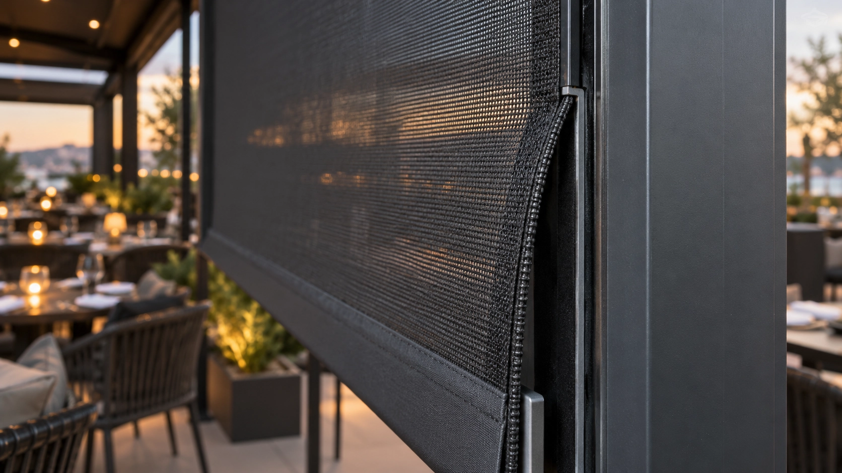 Close-up of a ZIP screen edge partially disengaged from the side guide on a commercial terrace