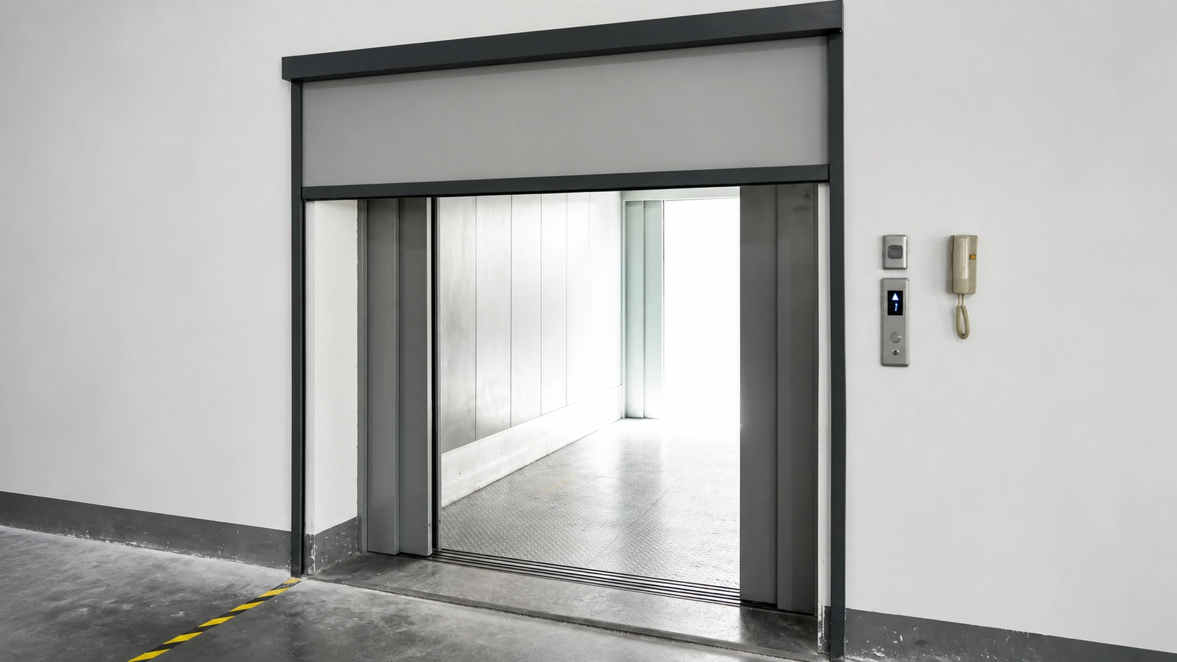 Guided factory partition blind closed beside a freight elevator route