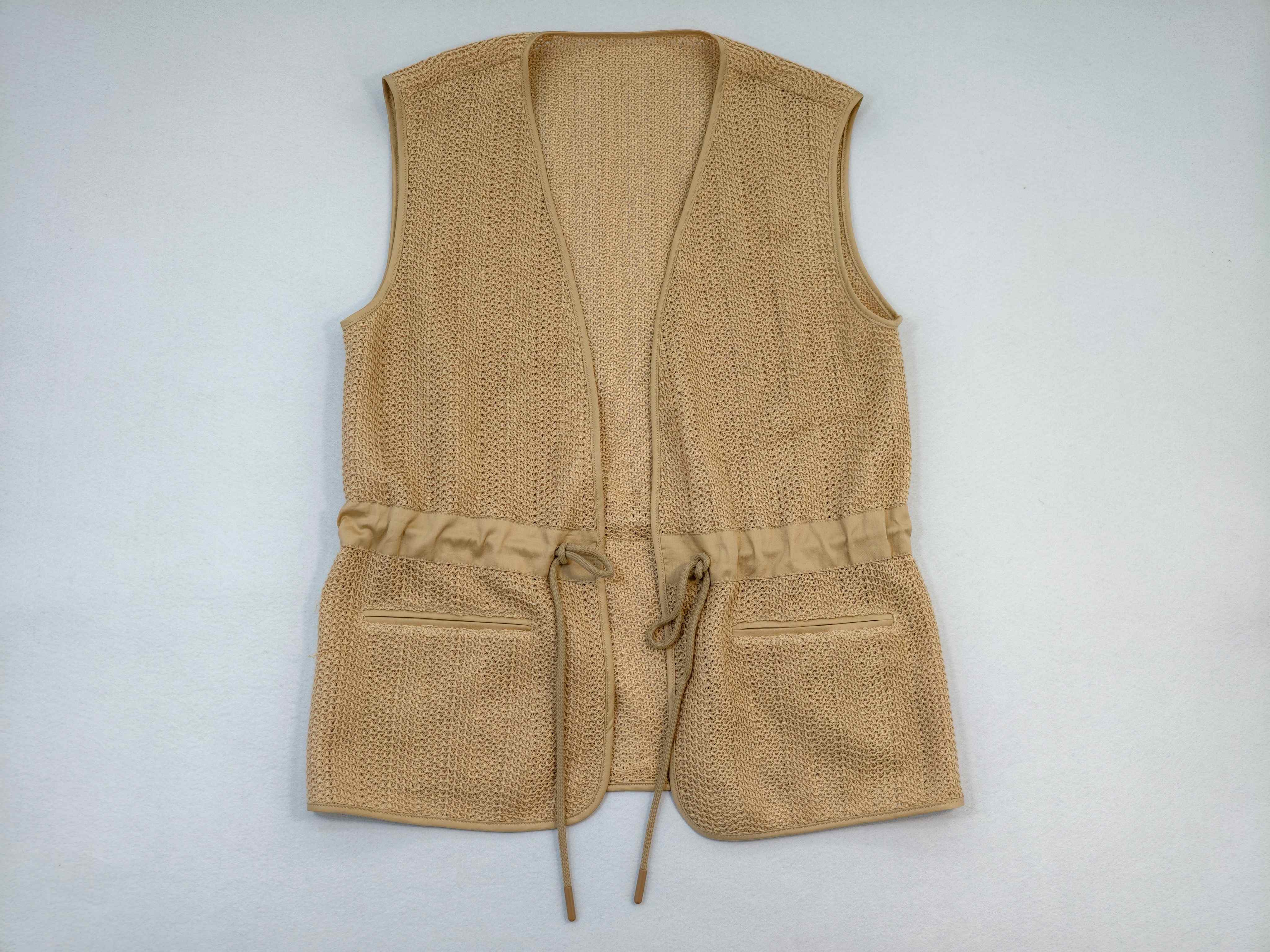 Beige open-knit utility vest with drawcord waist and pockets