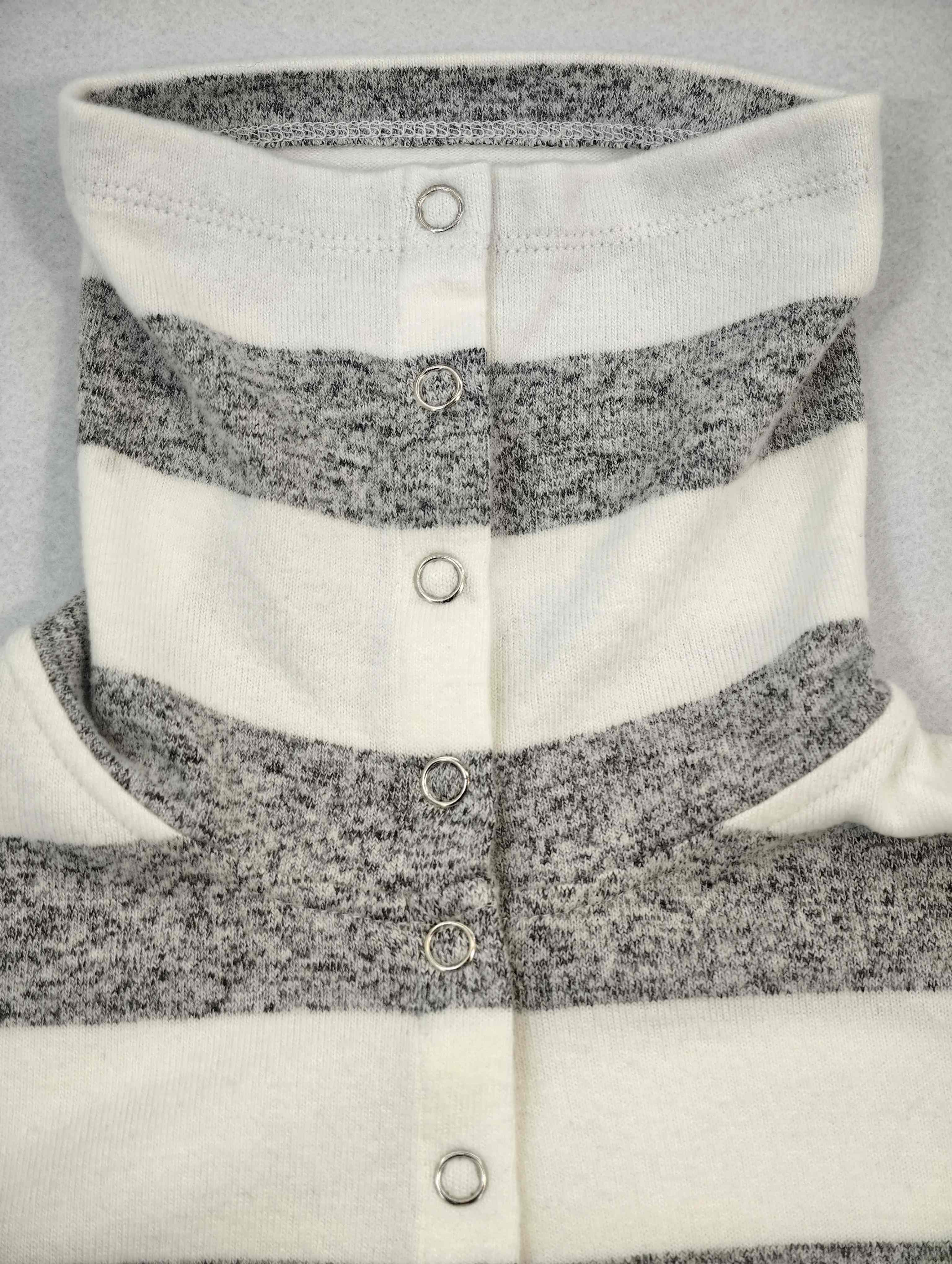 High neck and snap placket detail of brushed stripe top