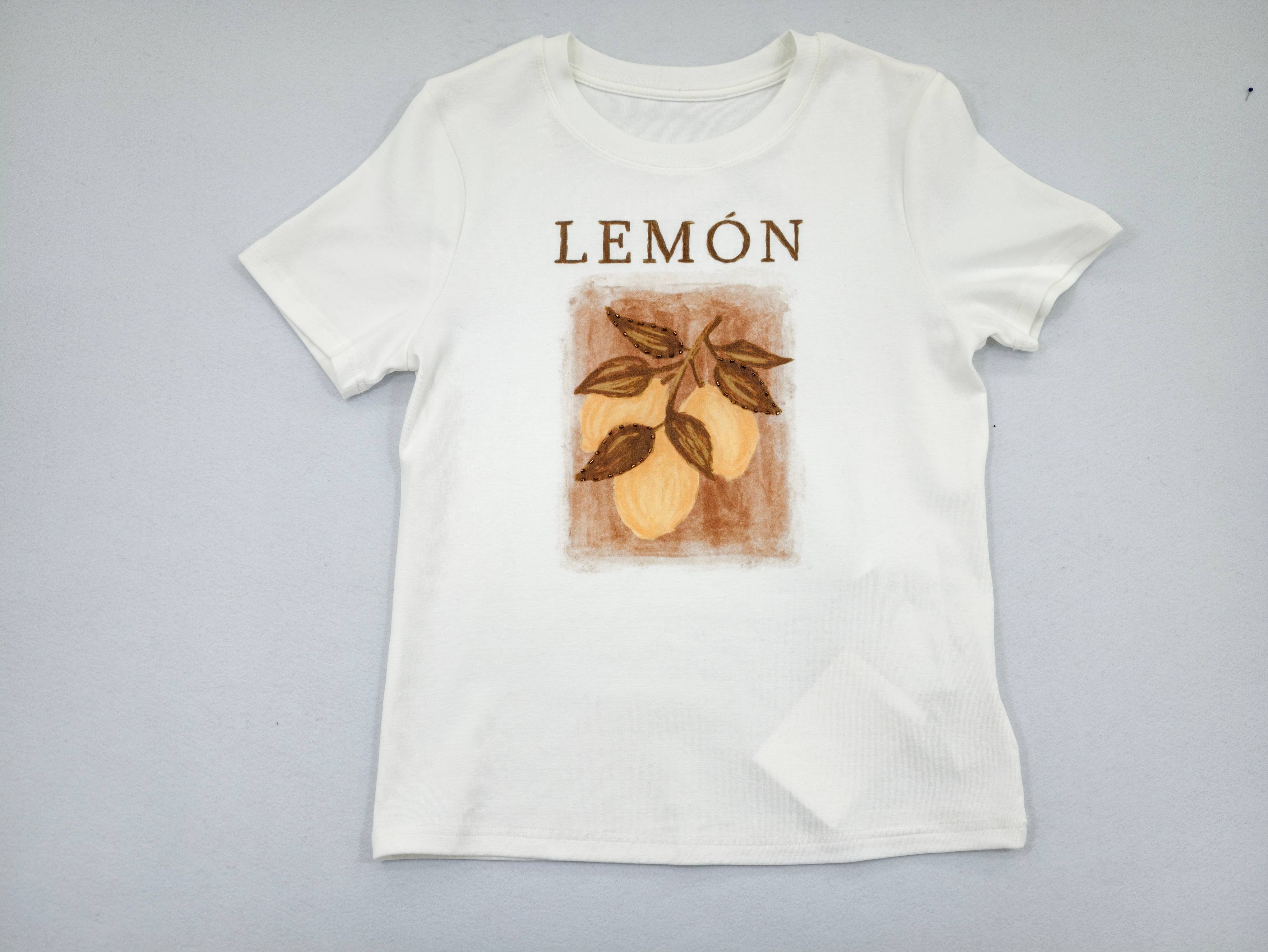 Lemon botanical artwork centered on white rib tee