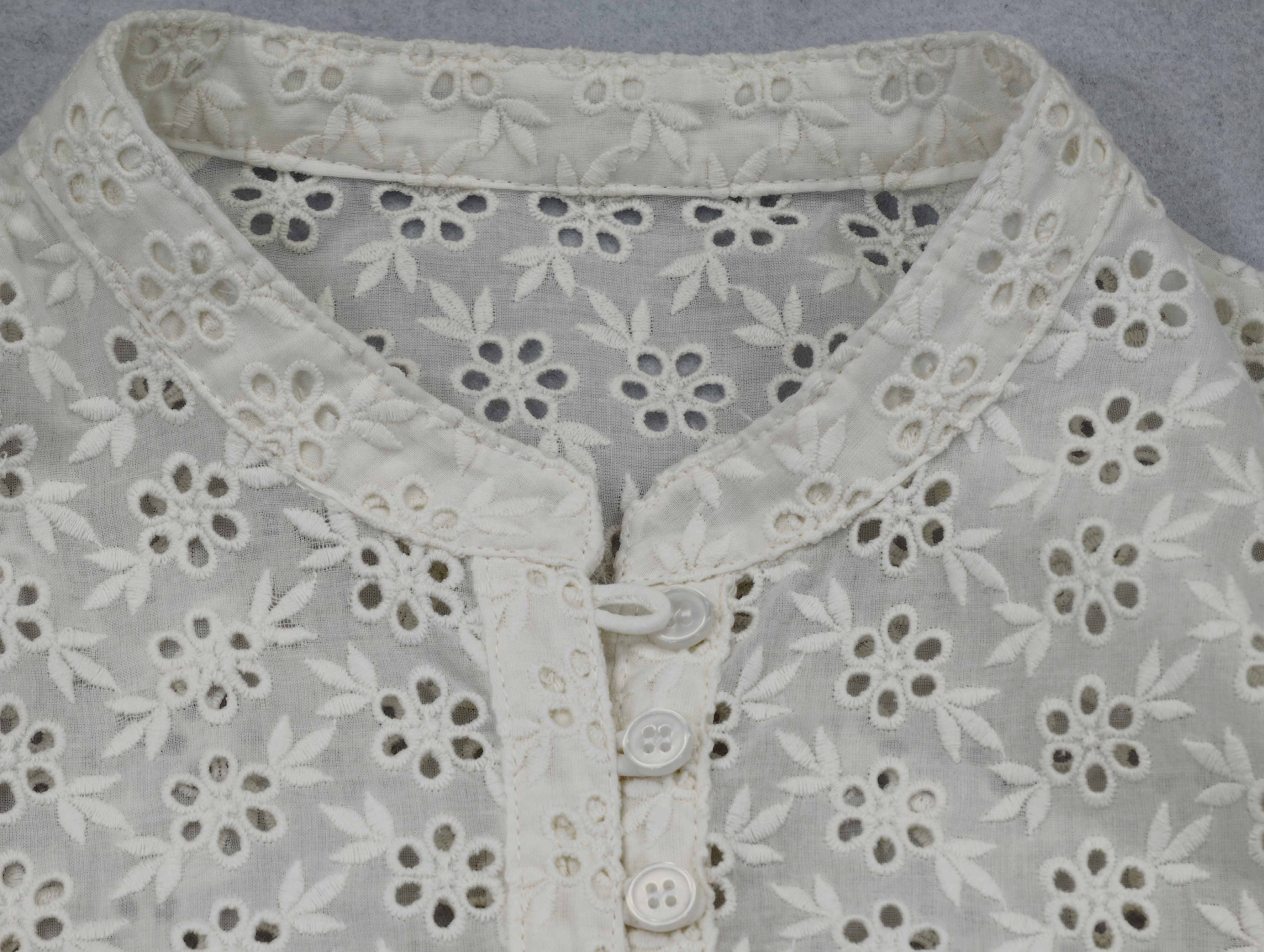 Band collar, loop buttons and embroidered placket close-up