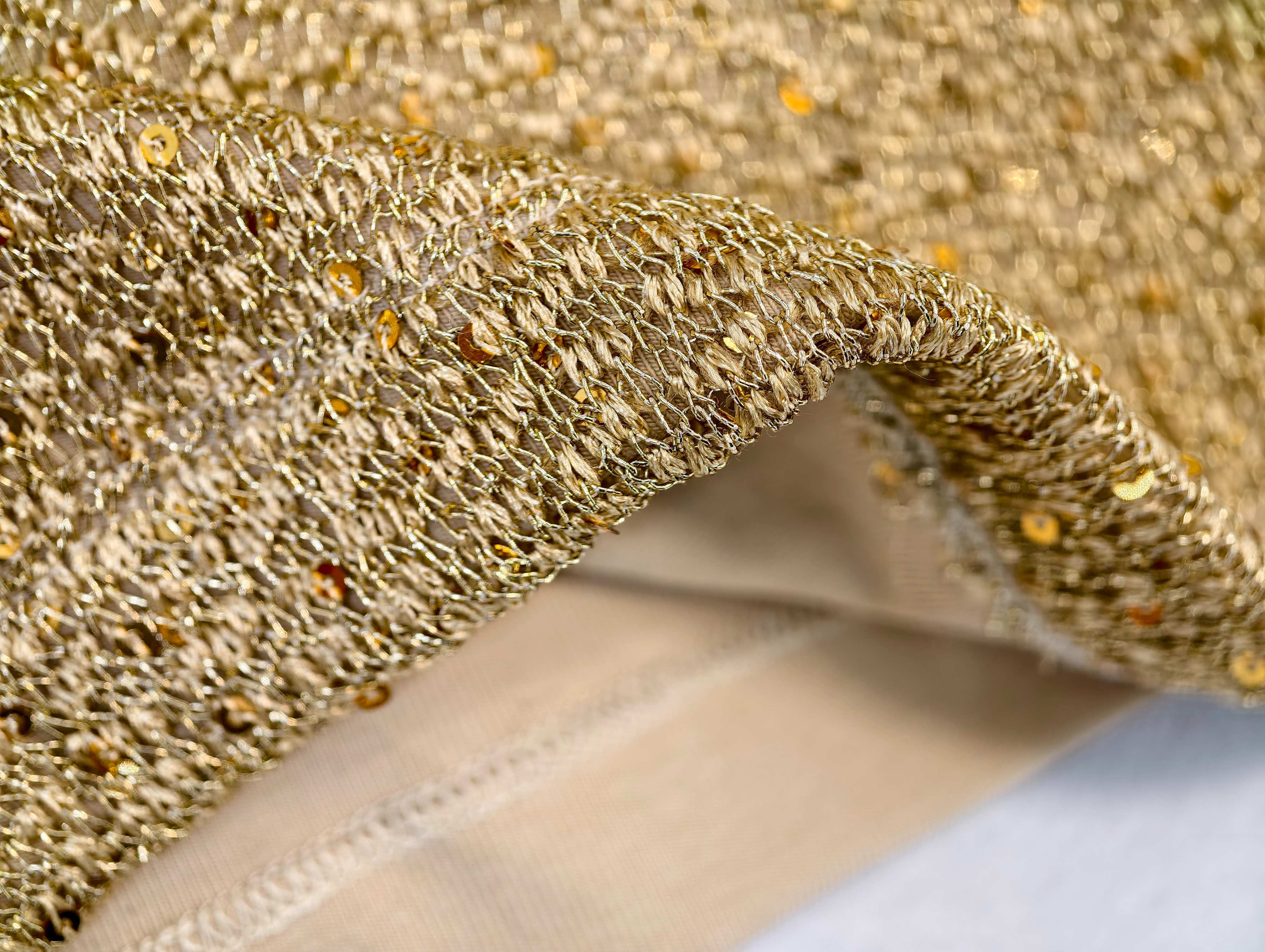 Gold textured knit fabric and layered hem construction