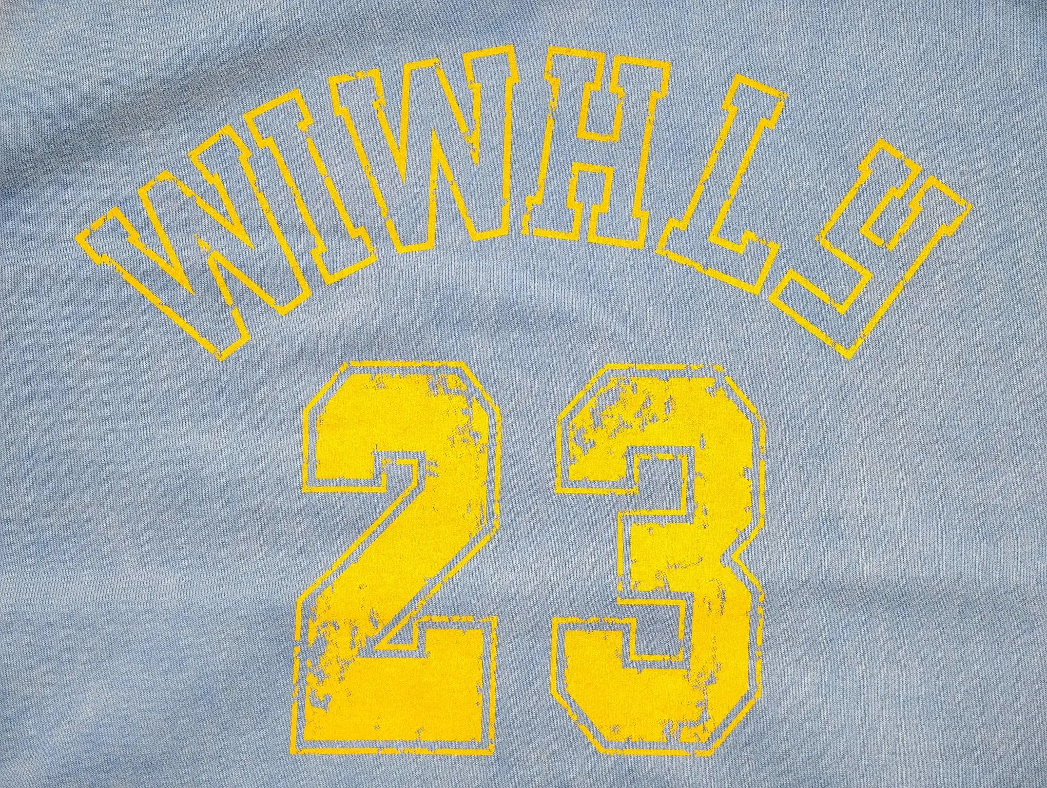 Distressed yellow varsity number print close-up