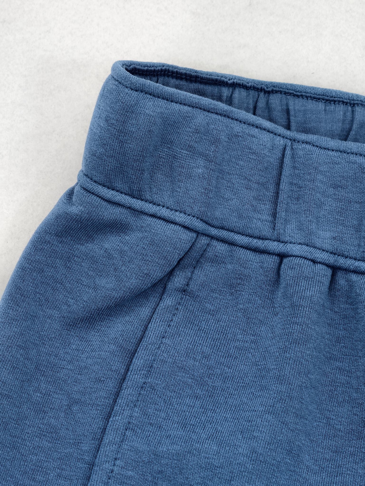Waistband and side pocket detail of knit pants