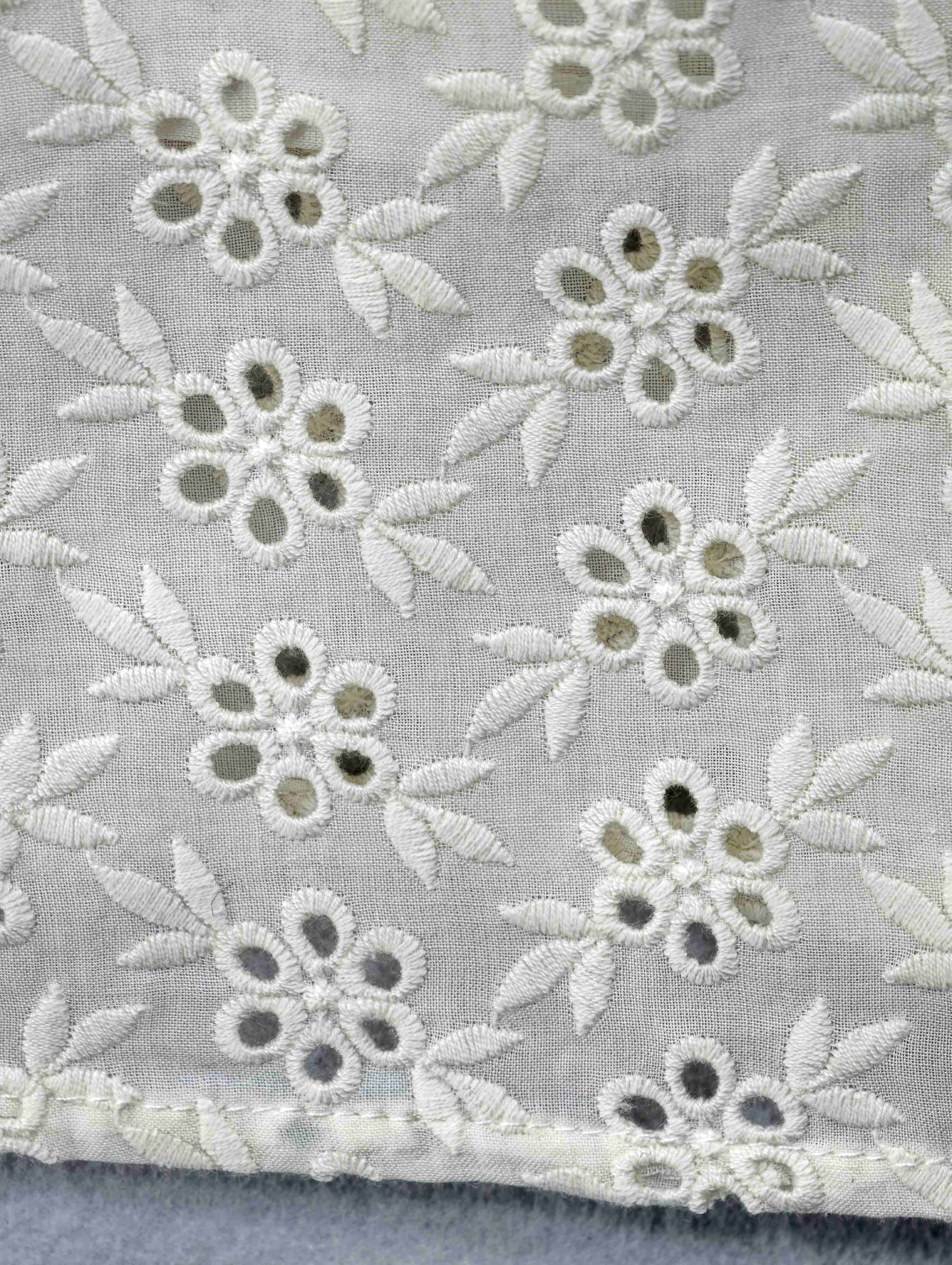 Floral eyelet embroidery on cotton fabric