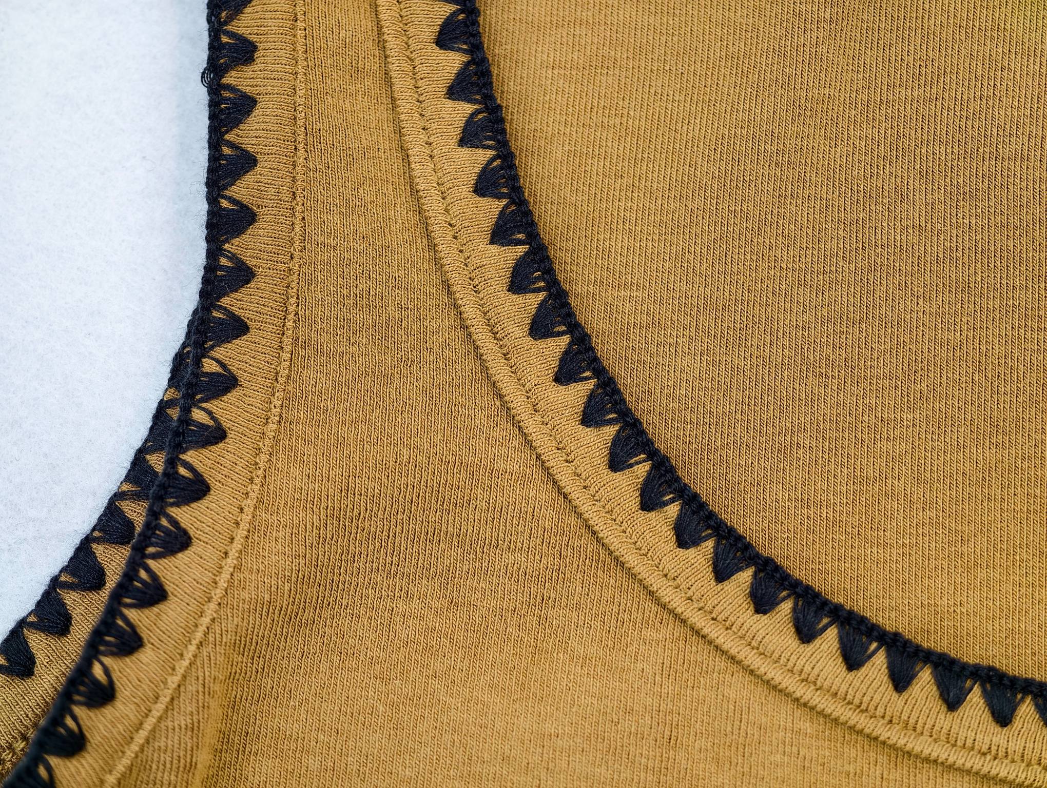 Black scalloped binding around neckline and armhole